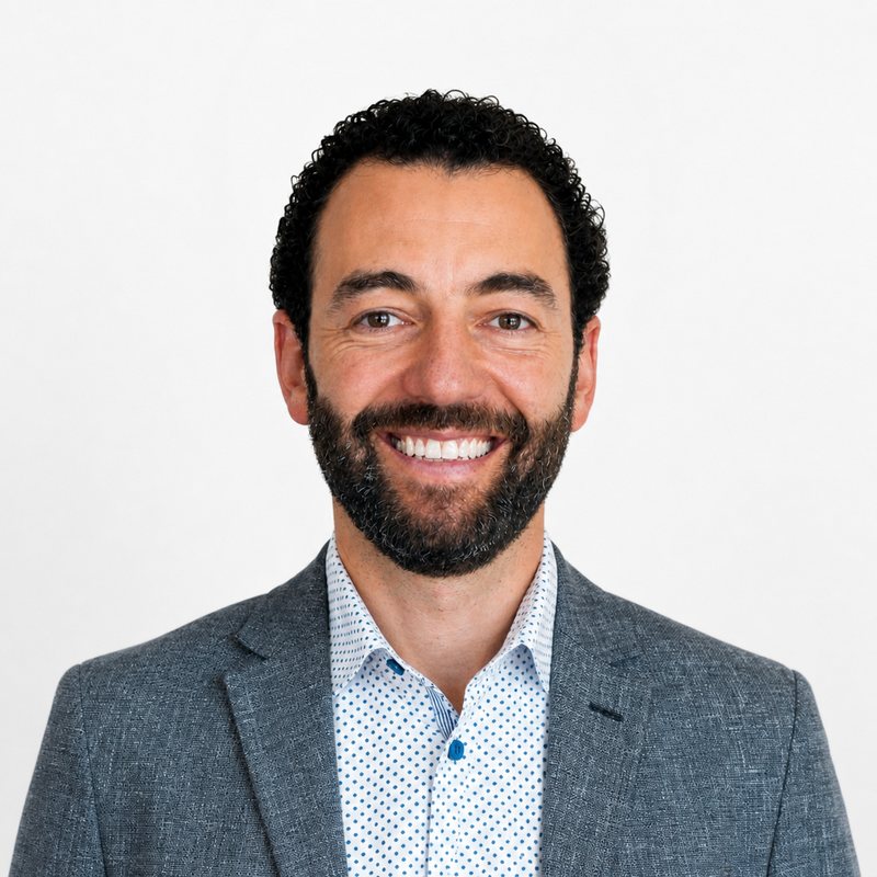 Alex Shoer in a gray blazer, smiling